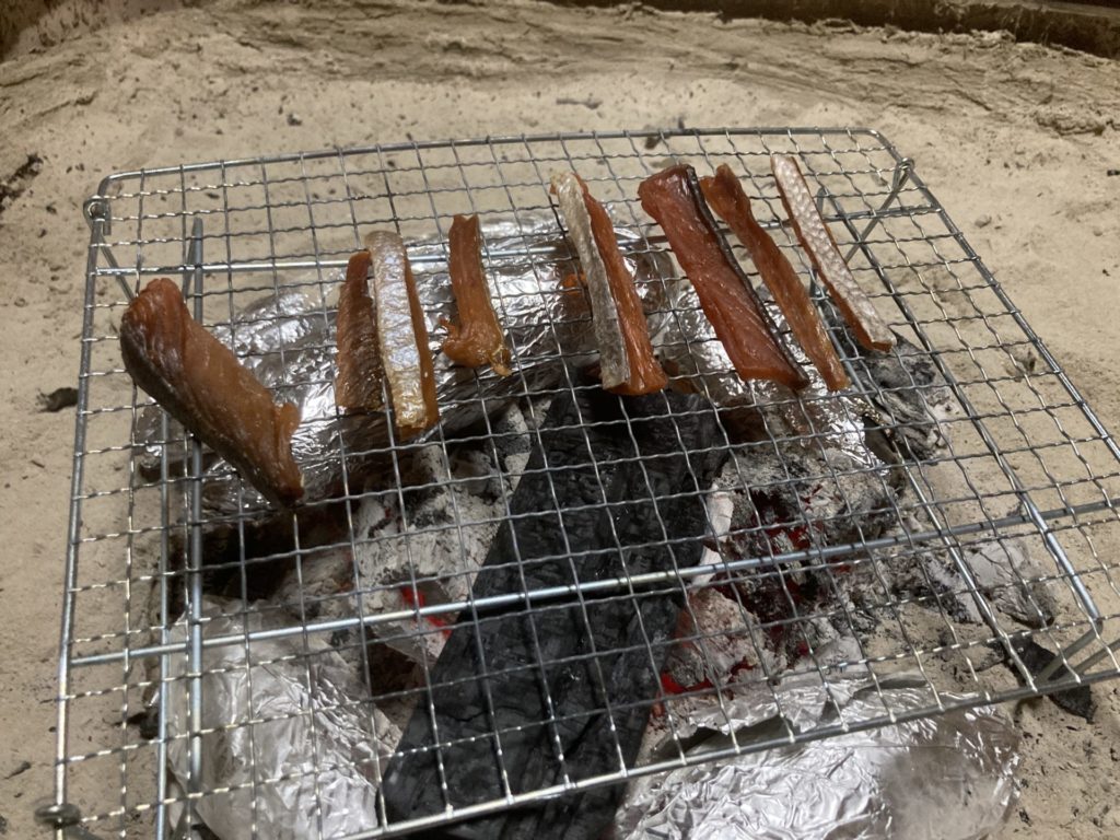 十文字ビレッジキャンプ場、ログハウス内の囲炉裏で鮭とばを炙る