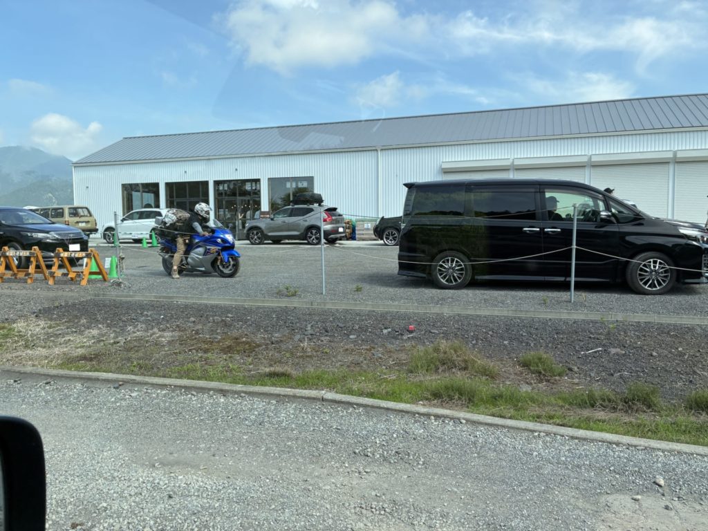 「富士高原トマトフィールドキャンプ場」ドライブスルーのように車が順番待ちとなっています（人間はチェックイン手続きのため店内）